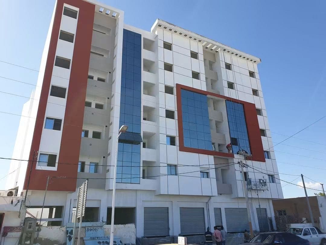 Façade blanche aux encadrements rouges et vitrage bleu