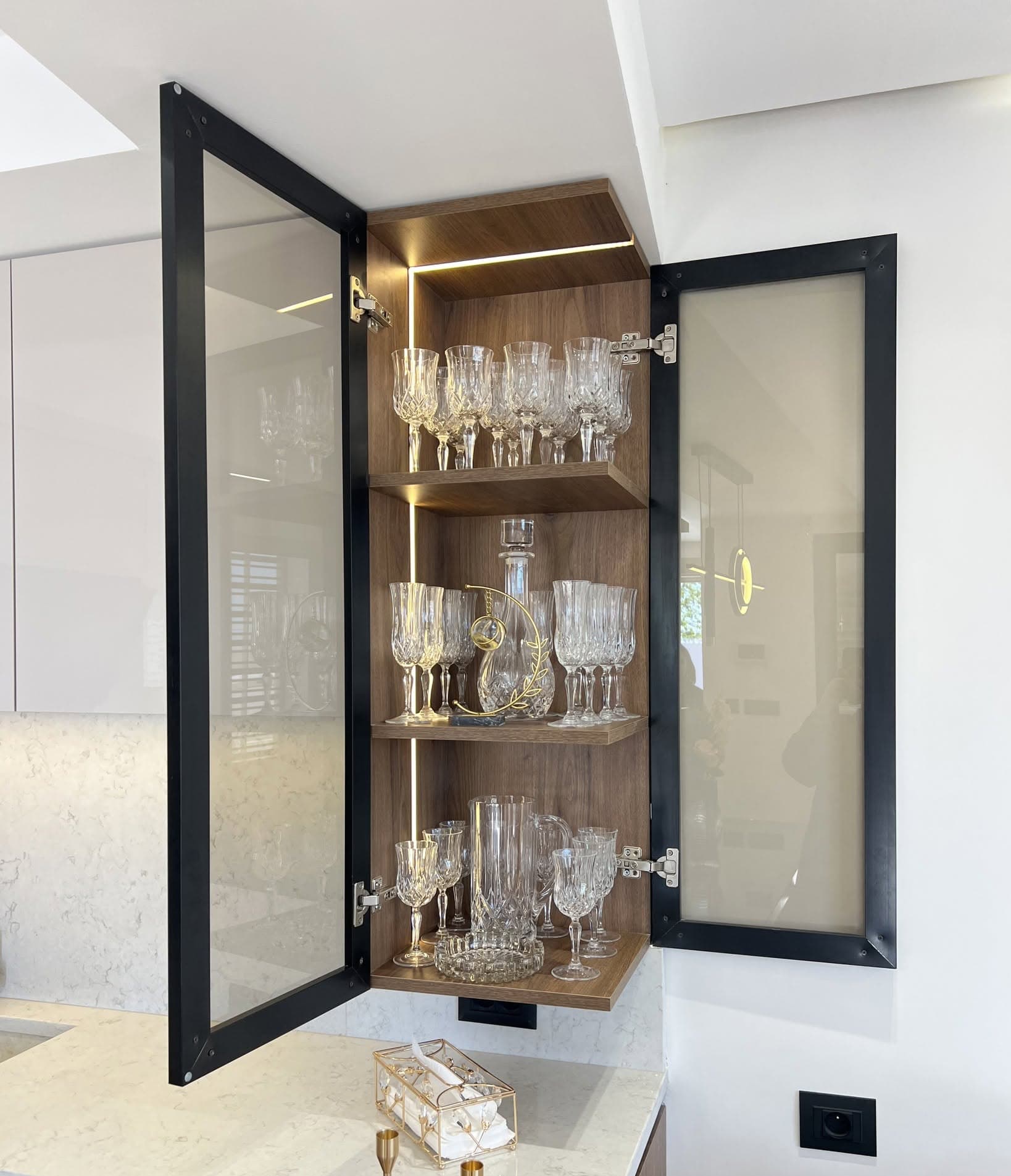 Vitrine sur mesure éclairée, ouverte sur une collection de verrerie